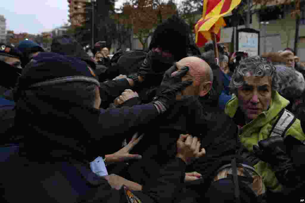 Catalan Mossos d&#39;Esquadra officers scuffle with demonstrators as they cordon off the area around Lleida museum in the west of Catalonia, Spain. Police in Spain&#39;s northeastern Catalan city of Lleida have clashed with people protesting a judicial ruling ordering the city&#39;s museum to return 44 pieces of religious art to the neighboring regional government of Aragon.
