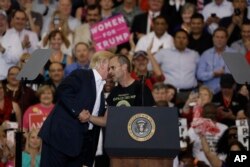President Donald Trump, left, with supporter Gene Huber during a campaign rally, Feb. 18, 2017, in Melbourne, Florida.