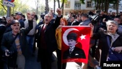 Relatives of detained military officers hold a portrait of Mustafa Kemal Ataturk, founder of modern Turkey, and shout slogans in front of a courthouse in Ankara October 9, 2013.
