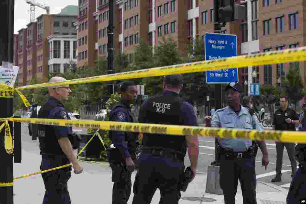  Polícia trabalha perto do cenário do tiroteio da manha de segunda-feira em Washington DC. (16 Set 2013)