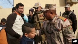 Civilians congratulate Lt. Gen. Riyadh Jalal Tawfiq, second from right, Iraqi ground forces commander as security forces patrol in the eastern side of Mosul, Iraq, Jan. 18, 2017. 