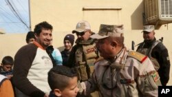 Warga memberi ucapan selamat kepada Letjen Riyadh Jalal Tawfiq (dua dari kanan), komandan pasukan darat Iran saat pasukan keamanan sedang berpatroli di wilayah timur kota Mosul, Irak, 18 Januari 2017. (AP Photo/ Khalid Mohammed). 