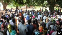 FILE - A U.N. refugee agency official speaks to civilians during a distribution of food items in Yei, in southern South Sudan, Nov. 15, 2016. The formerly peaceful town of Yei became a center of country's renewed civil war, gripped by killings among the d