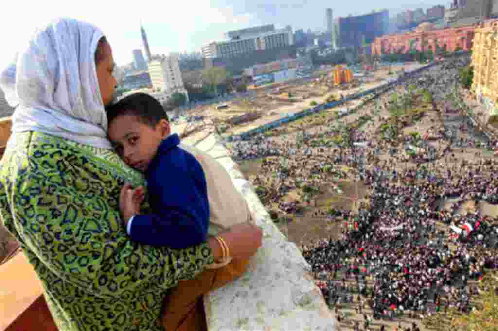 An Egyptian mother hugs her child as she watches some thousands of Egyptian protesters gather in Tahrir Square