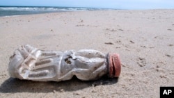 A discarded plastic bottle lies on the beach at Sandy Hook, N.J. on Tuesday, April 2, 2019. (AP Photo/Wayne Parry)