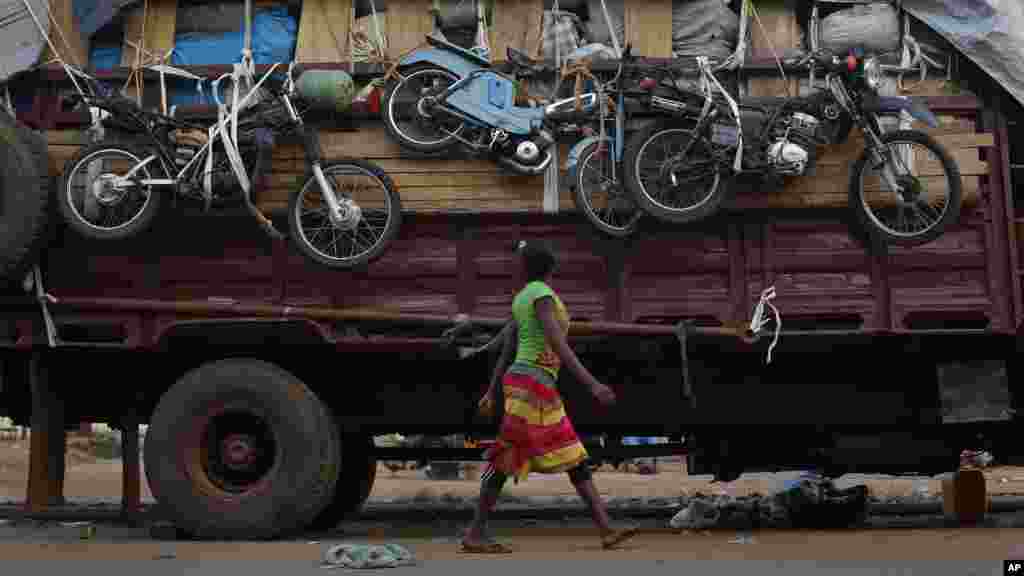 A woman walks past a truck waiting to leave for Chad loaded with goods belonging to Muslim residents of the PK5 district of Bangui, Central African Republic, April 9, 2014. 