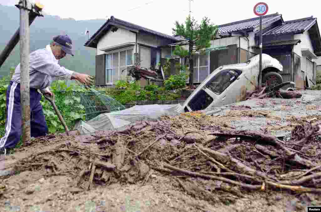Warga membersihkan puing-puing setelah topan Neoguri melanda kota Nagiso, Nagano, Jepang.