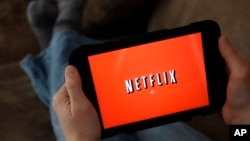 FILE - A Netflix user displays a tablet in North Andover, Mass, January 17, 2014. 