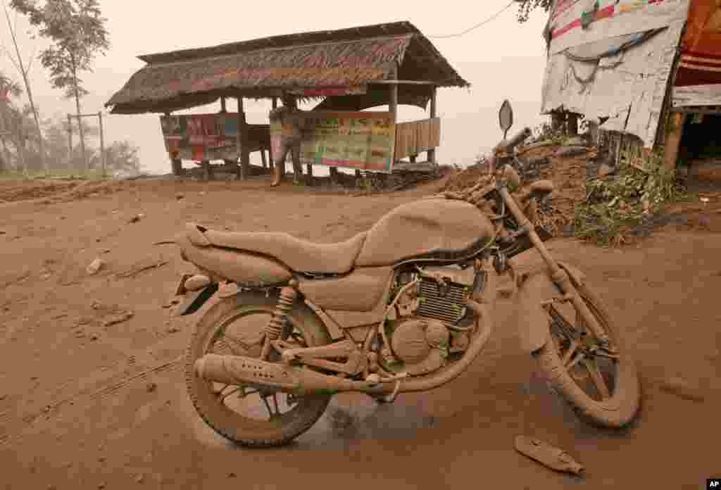 A motorcycle is covered in volcanic ash from an eruption of Mount Sinabung in Tiga Pancur, North Sumatra, Indonesia, Jan. 4, 2014. 