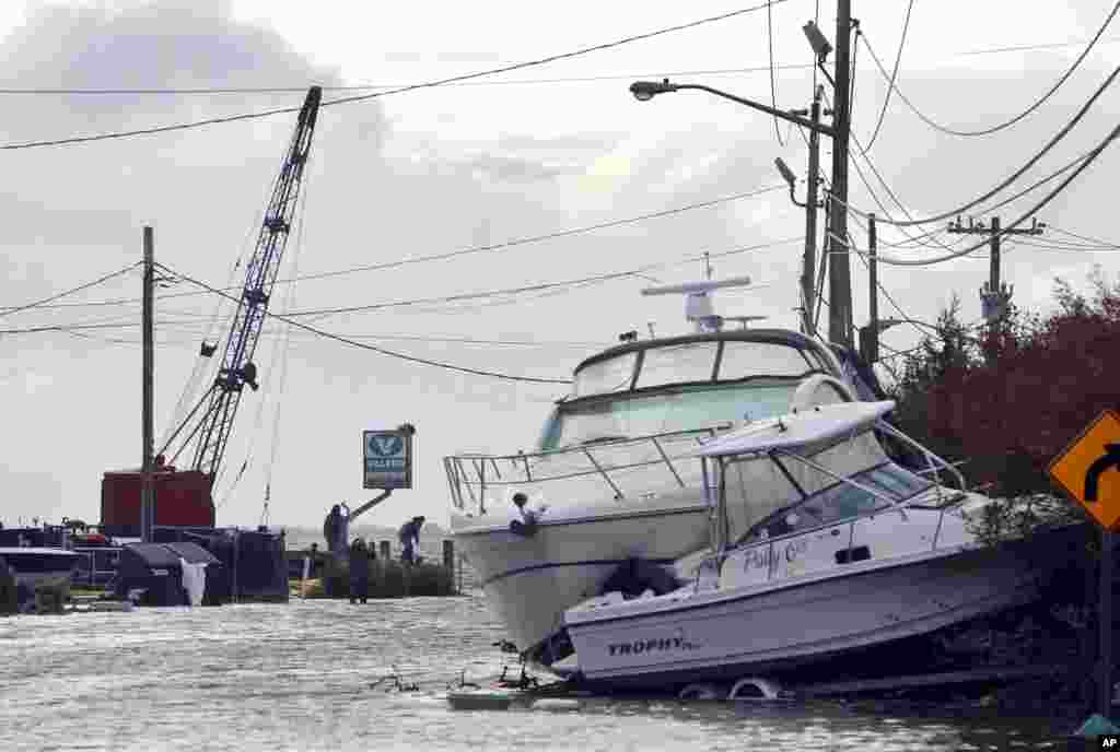 Boats lie piled up as people work to secure a fuel dock in the wake of superstorm Sandy, October 30, 2012, in West Babylon, New York.
