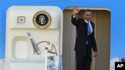 President Barack Obama waves as he boards Air Force One before departing the Orlando International Airport for Washington to monitor Hurricane Sandy, in Orlando, Florida, October 29, 2012.