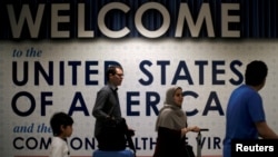 FILE - International passengers arrive at Washington Dulles International Airport.