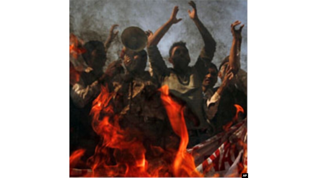 Protesters yell anti-American slogans while burning a poster of Pakistan Prime Minister Yousuf Raza Gilani, to condemn the government's support of the U.S., Multan, November 29, 2011