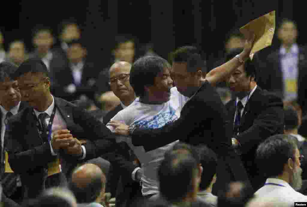 Pro-democracy lawmaker Leung Kwok-hung is dragged away by security guards as he protests against Li Fei, Hong Kong, Sept. 1, 2014.