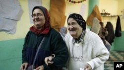 Egyptian women leave a polling station after casting their votes during a parliamentary election in Cairo, November 29, 2011.