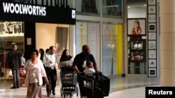 Shoppers leave a Woolworths store at a shopping centre in Lenasia, south of Johannesburg. Taken 8.28.2013