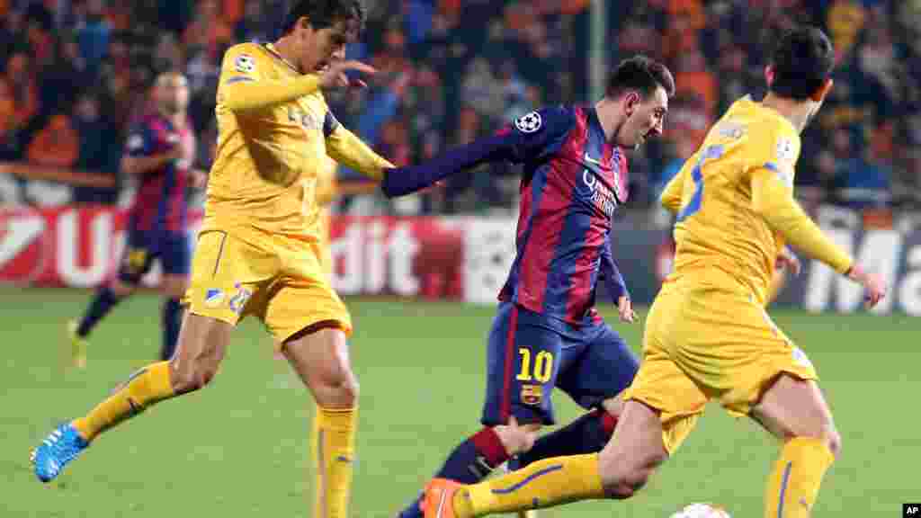 Lionel Messi de Barcelone, au centre, slalome entre Marios Antoniades, à droite, et Nuno Morais, à gauche, lors du match de football de la Ligue des Champions Groupe F entre Apoel et Barcelone, au stade GSP, à Nicosie, Chypre, le mardi 25 novembre 2014.