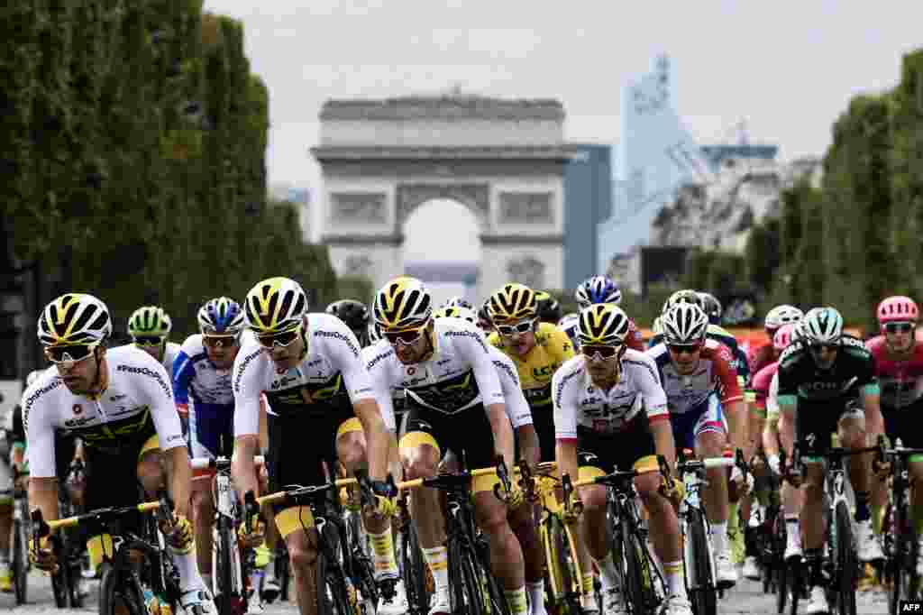 (L-R) Spain&#39;s Jonathan Castroviejo, Great Britain&#39;s Christopher Froome, Netherlands&#39; Wout Poels, Great Britain&#39;s Geraint Thomas, wearing the overall leader&#39;s yellow jersey, and Poland&#39;s Michal Kwiatkowski ride in the pack in front of the Arc de triomphe monument during the 21st and last stage of the 105th edition of the Tour de France cycling race between Houilles and Paris Champs-Elysees.