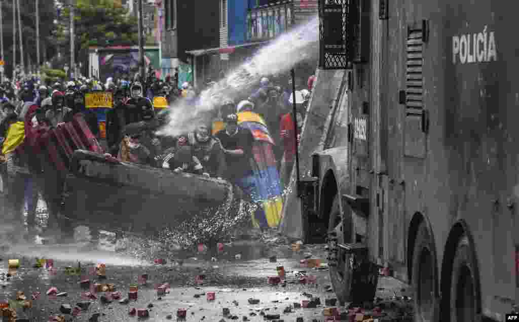 Police officers spray a water cannon at demonstrators during a protest against the government of Colombian President Ivan Duque in Bogota, June 9, 2021.