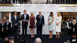 FILE - Then-candidate Donald Trump, accompanied by his family, speaks during the grand opening of the Trump International Hotel-Old Post Office, Washington, Oct. 26, 2016. Experts on government ethics warned Trump that he’d never shake suspicions of a clash between his private interests and the public good if he didn't sell off his vast holdings.