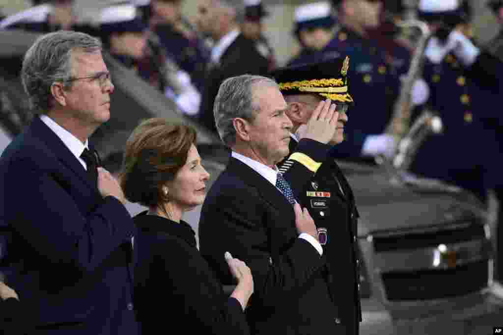 President George W. Bush, his wife Laura Bush and brother Jeb Bush watch as the casket of former President George H.W. Bush arrives at the National Cathedral, Dec. 5, 2018, in Washington, for a State Funeral.