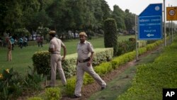 FILE - Indian policemen secure the area outside the Pakistan High Commission as Kashmiri separatist leaders arrive for talks with the Pakistani high commissioner in New Delhi, India.