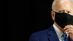 Joe Biden duke hequr maskën përpara një fjalimi