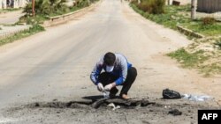 FILE - A Syrian man collects samples from the site of a suspected toxic gas attack in Khan Sheikhun, in Syria’s northwestern Idlib province, April 5, 2017.