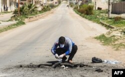 A Syrian man collects samples from the site of a suspected toxic gas attack in Khan Sheikhun, in Syria’s northwestern Idlib province, April 5, 2017.