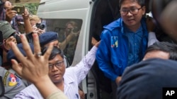 Reuters journalist Thet Oo Maung Maung, known as Wa Lone, exits a police van while his wife Pan Ei Mon waves upon his arrival at the township court for an appearance Wednesday, Dec. 27, 2017, outside Yangon, Myanmar.