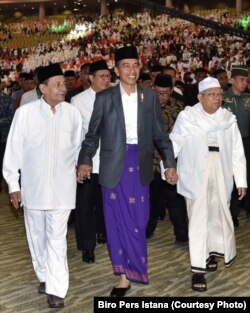 Presiden Jokowi bergandengan dengan Rais ‘Aam Jam’iyyah Ahlith Thariqah Habib Luthfi bin Ali bin Yahya (kiri) dan Rais 'Aam Nahdlatul Ulama KH Ma'ruf Amin (kanan) dalam Festival Sholawat Nusantara di Sentul, Sabtu, 24 Februari 2018. (Foto: Biro Pers Istana)