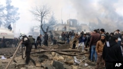 Rescue workers attend to the wreckage left by a bomb that went off in a busy market in the rebel-held Syrian town of Azaz along the Turkish border, Jan. 7, 2017.