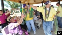 FILE - Seniors enjoy a Mardi Gras parade after they helped build a park in Houma, La. A new survey suggests pessimistic feelings held by people earlier in life take an optimistic turn as they move toward old age. 