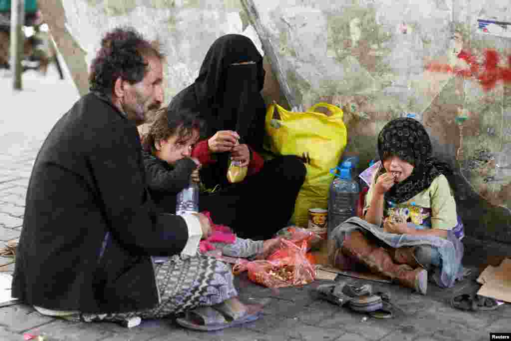 خانواده بی‌ خانمان در خیابانی در صنعا یمن ناهار می‌‌خورند. آتش بس شکننده در یمن آغاز شده است.