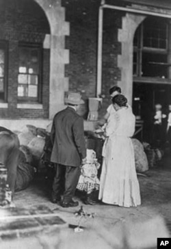 These immigrants gather around the family's belongings at the Ellis Island processing center. In the time it took them to pass inspection, they may have taken a new last name.