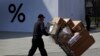 A delivery worker pushes boxes of goods at the capital city's popular shopping mall in Beijing, April 4, 2019. The U.S. and China opened a ninth round of talks Wednesday, aiming to further narrow differences in an ongoing trade war.