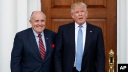 President-elect Donald Trump (R) calls out to the media as he and former New York mayor Rudy Giuliani pose for photographs at the Trump National Golf Club Bedminster clubhouse, Nov. 20, 2016, in Bedminster, New Jersey. A long-time Trump loyalist, Giuliani is said to still be in the running for secretary of state.