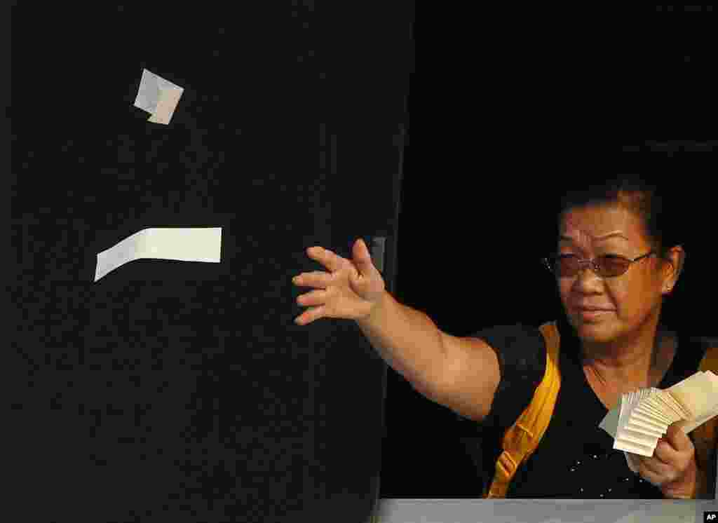 A relatives of the victim throws paper money as she pays tribute to the ill-fated people aboard a boat that sank Monday night near Lamma Island, off the southwestern coast of Hong Kong Island, October 2, 2012