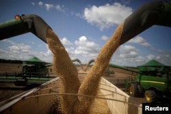 FILE - Harvesting machines are in operation during the opening ceremony of the Grain Harvest in Caseara, Brazil, Feb. 15, 2018.