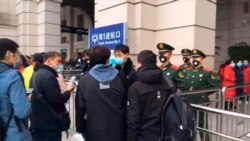 Pasukan keamanan memeriksa para turis yang akan memasuki stasiun kota Wuhan sebelum ditutup minggu ini (foto: dok).
