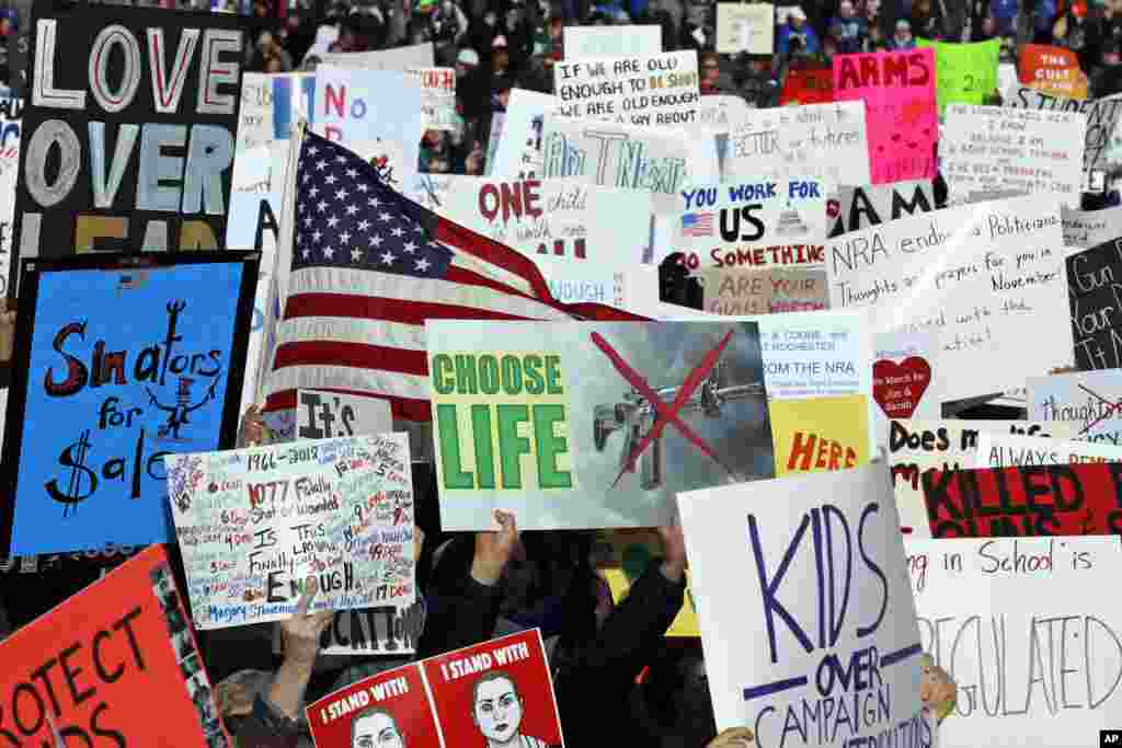 Crowds of people hold signs on Pennsylvania Avenue in Washington.