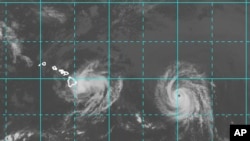 This image provided by NOAA taken at 2 a.m. EDT Friday Aug. 8, 2014 shows Hurricane Iselle approaching the Island of Hawaii, left as Hurricane Julio with a well defined eye follows. (AP Photo/NOAA)