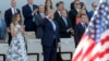 Le président des États-Unis Donald Trump, au milieu, la première dame des États-Unis, Melania Trump, à gauche, et le président français, Emmanuel Macron, à droite, saluent les militaires au le défilé traditionnel de la Bastille Day sur les Champs Elysées,