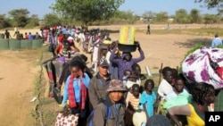 In this photo taken Wednesday, Dec. 18, 2013 and released by the United Nations Mission in South Sudan (UNMISS), civilians fleeing violence seek refuge at the UNMISS compound in Bor, capital of Jonglei state, in South Sudan.