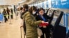 Une passagère portant un masque de protection obtient sa carte d'embarquement à l'aéroport international Adolfo Suarez-Barajas à la périphérie de Madrid, en Espagne, le mercredi 11 mars 2020. (AP Photo / Bernat Armangue)