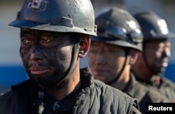 FILE - Miners wait in lines to shower during a break near a coal mine in Heshun county, Shanxi province, Dec. 5, 2014.