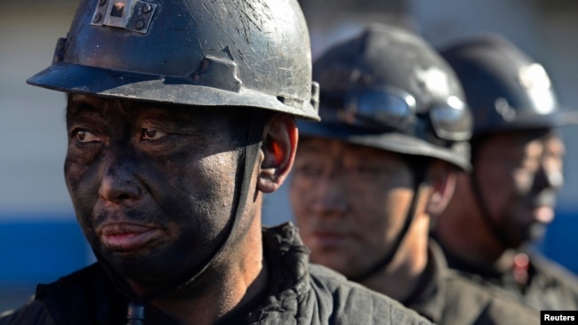 中国陕西省一家煤矿的矿工下班后排队淋浴 - 资料照片