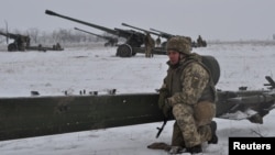 A Ukrainian service member is seen next to a howitzer during artillery and anti-aircraft drills near the border with Russian-annexed Crimea in the Kherson region, Ukraine, in this handout picture released Jan. 28, 2022. 