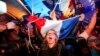 FILE - Supporters of far-right candidate Marine Le Pen, celebrate in Henin-Beaumont, northern France, after exit poll results of the first round of the presidential election are announced, April 23, 2017.