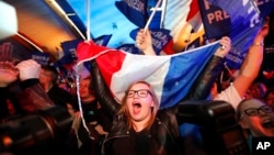 FILE - Supporters of far-right candidate Marine Le Pen, celebrate in Henin-Beaumont, northern France, after exit poll results of the first round of the presidential election are announced, April 23, 2017.